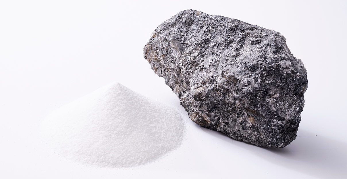 Una persona trabajando en una mina, lleva un chaleco amarillo y un casco blanco